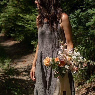 a picture of Becca in the sunshine holding a bouquet of flowers
